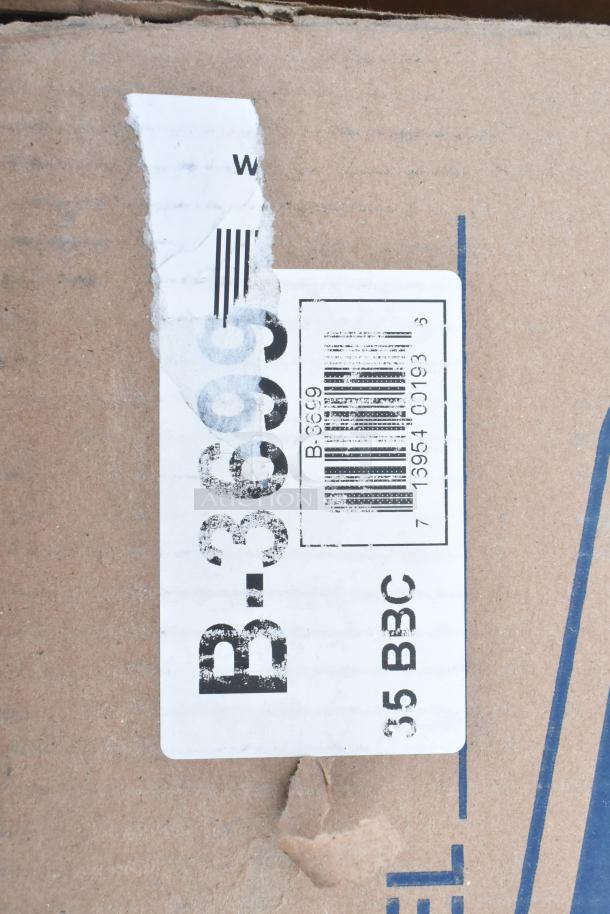 Cardboard box showing barcode label with markings: "B-3699," partially torn label. Contains scratch and dent items.
