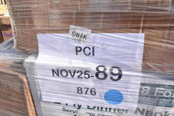 Stacked boxes wrapped in plastic, labeled "PCI NOV25-89," containing 24 new scratch and dent items like towels and trays.