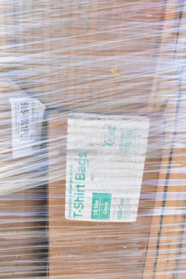 Plastic-wrapped pallet of various boxes labeled for T-shirt bags, condition unknown. Contains berry baskets, food cups, and container lids.