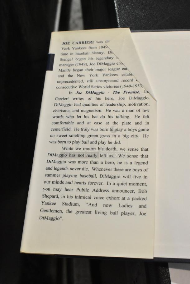 "Joe DiMaggio - The Promise" book, visible text praising DiMaggio, minor creasing on page corner, good condition.