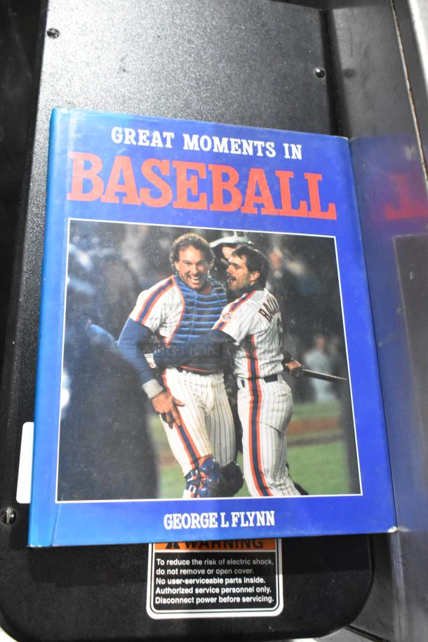 "Great Moments in Baseball" book by George L. Flynn, featuring iconic cover photo; vibrant blue jacket, in good condition.