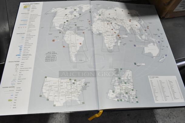 Open atlas book displaying world map with key, symbols, and city map index. Pages are in good condition.