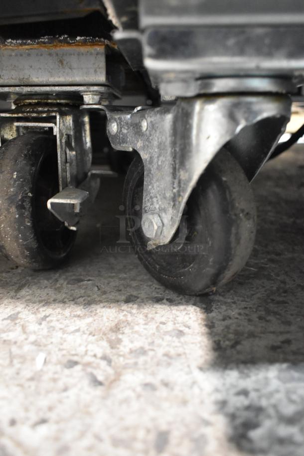 Ikon KB27F freezer caster wheel, showing durable commercial casters for easy mobility on textured floor.