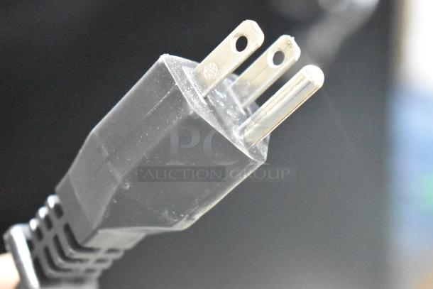 Close-up of a three-prong electrical plug of a brand new Robot Coupe R 2 Dice food processor.