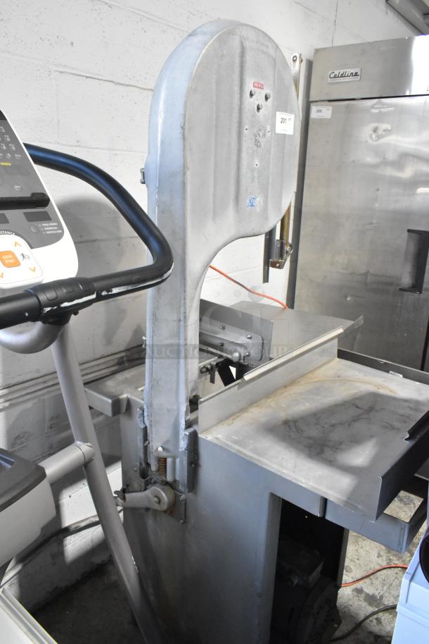 Metal commercial floor style meat saw, 208 volts, 3 phase. Shows signs of use. Sturdy build, ideal for industrial settings.