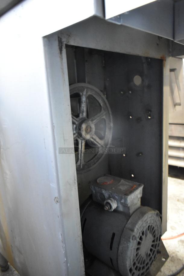 Metal commercial floor style meat saw, 208 volts, 3 phase. Shows motor and pulley system, used condition.