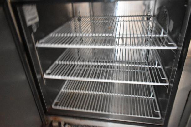 Interior of Atosa reach-in cooler featuring metal wire shelves, commercial kitchen-grade, part of Stuff4less trailer setup.