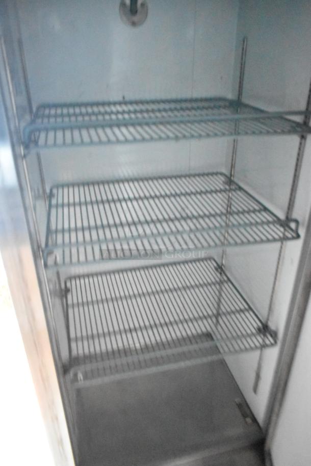 Interior of a Stuff4less mobile kitchen showing metal cooling racks inside a commercial-grade reach-in cooler.