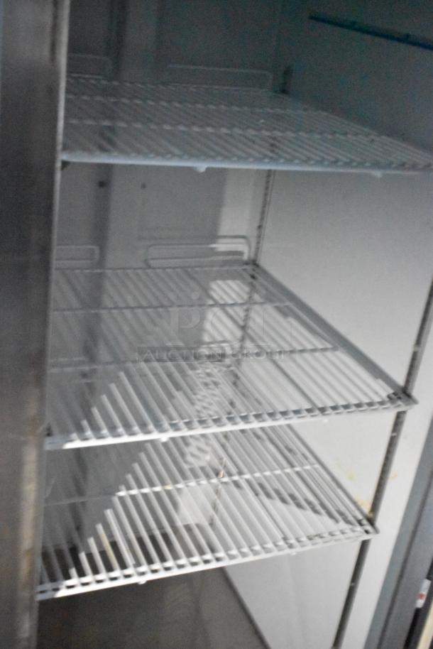 Interior of Atosa reach-in cooler with multiple wire shelves, part of a fully equipped 24' mobile kitchen trailer auction.