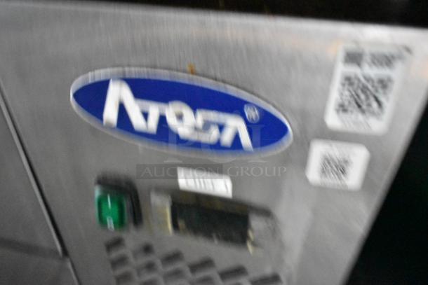 Blurry image of Atosa equipment in a Stuff4less 24' fast food trailer, showing brand label and operating button.