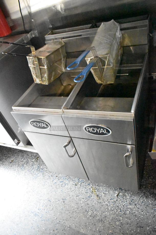 Royal gas fryers in a mobile kitchen, featuring stainless steel construction and dual frying baskets, ready for use.