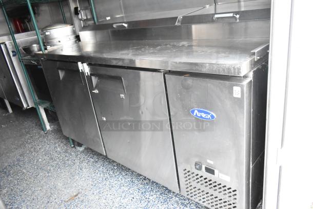 Atosa prep table in a fully outfitted 24' fast food trailer, featuring commercial-grade equipment for diverse concepts.