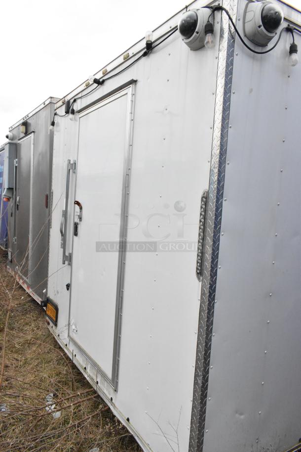 24' mobile kitchen trailer, white exterior, security cameras, metal door with handle, suited for food service startups.