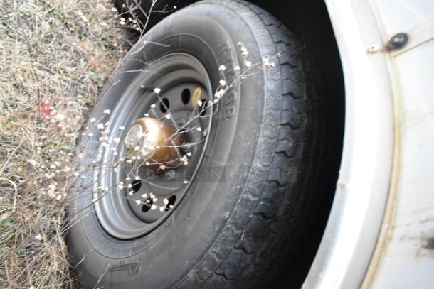 Close-up of a tire on a Stuff4less 24' fast food trailer, showing good tread condition and part of the metal wheel rim.