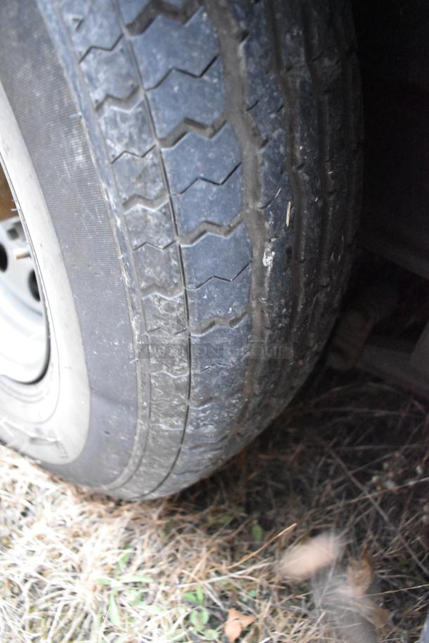 Close-up of a tire on the Stuff4less 24' fast food trailer, showing tread condition and wheel rim.