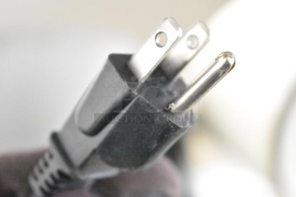 Close-up of a power plug for a Philips HD96654 countertop air fryer, 120 volts, showing three-prong design.