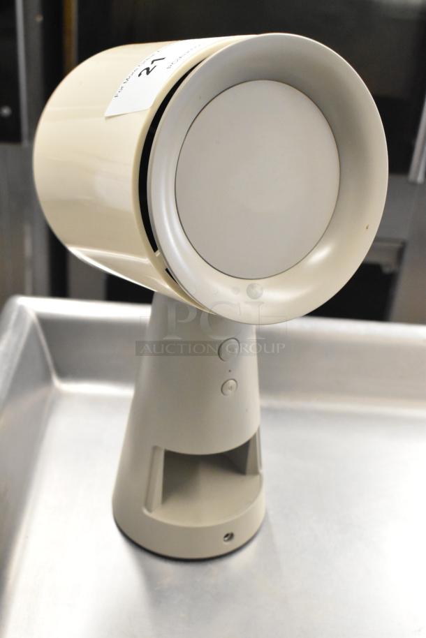 Portable countertop range hood, beige color, sleek design, gentle curves, control buttons on base, in good condition.