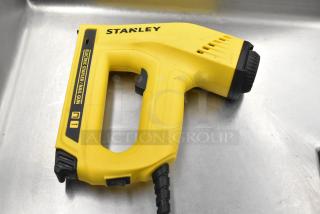 Stanley Electric Stapler/Nail Gun, yellow, in good condition, labeled with brand and function, cord attached.