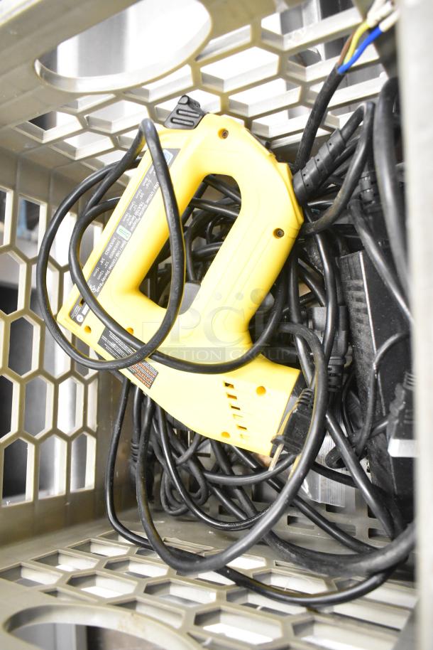 Stanley Electric Stapler/Nail Gun, yellow, coiled cord, placed in metal crate, visible labels with specs and safety information.