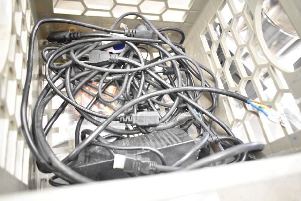 A crate filled with assorted black power cables and electronic connectors. Stanley Electric Stapler / Nail Gun not visible.