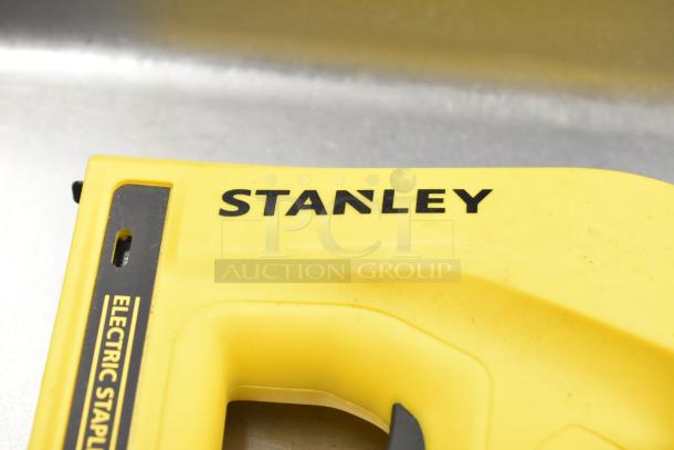 Stanley Electric Stapler/Nail Gun, yellow, with visible branding and "Electric Stapler" label, in good condition.