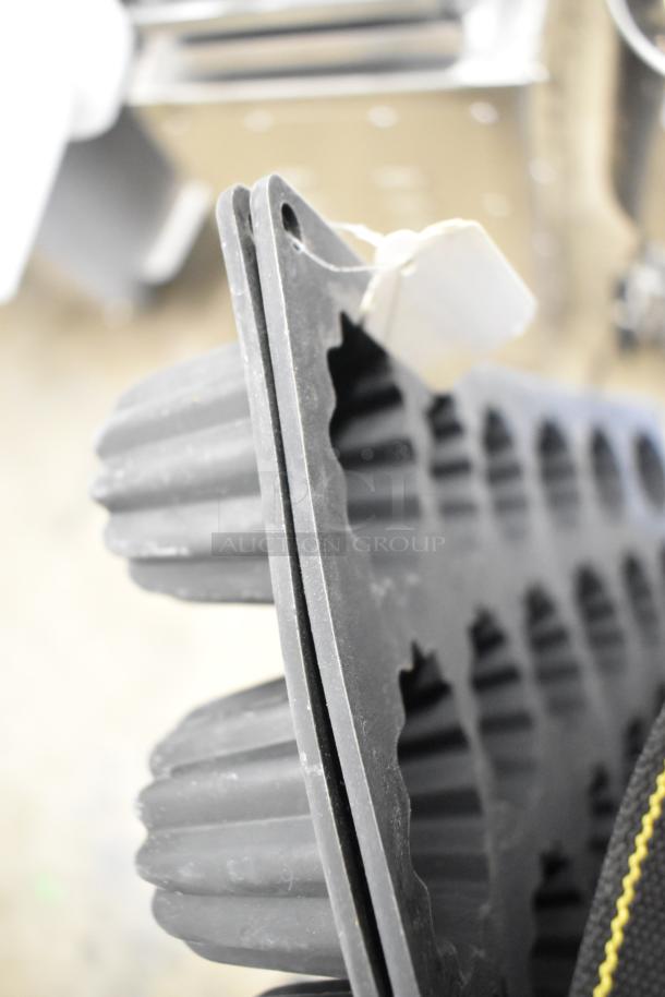 Silicone mold baking pan liner with cavities, showing detail of the flexible material, tag attached with no visible text.