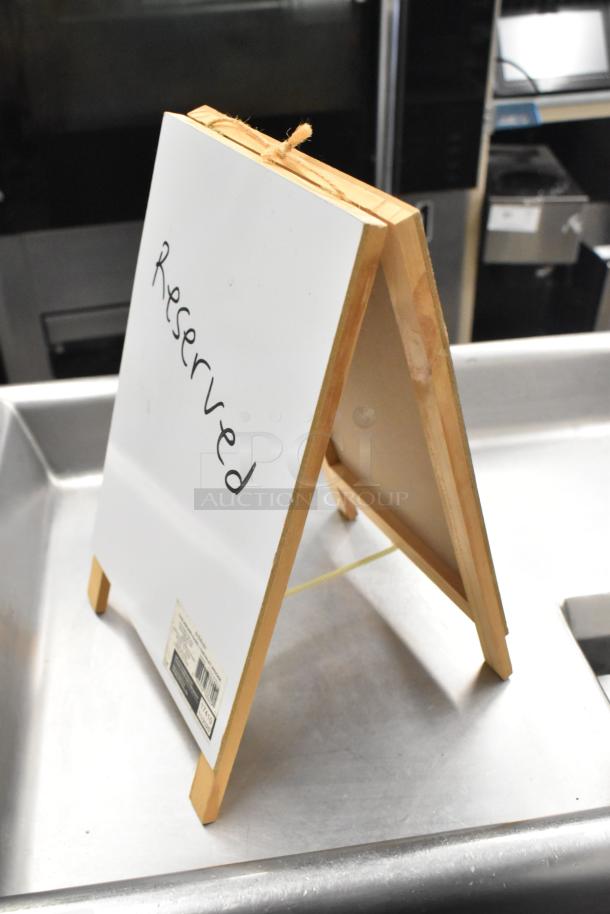"Reserved" countertop sign with wooden frame, A-frame style, on stainless steel surface, in good condition.