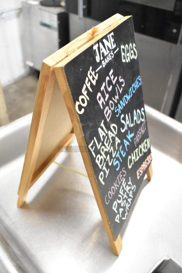 Wooden countertop sign with "Jane Bakes" menu items listed. Includes coffee, eggs, rice, salads, pasta.