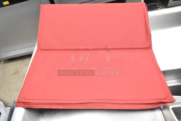 Red mold baking pan liner, fabric material, excellent condition, part of a lot with countertop signs and a Waring Panini Press grease trap.