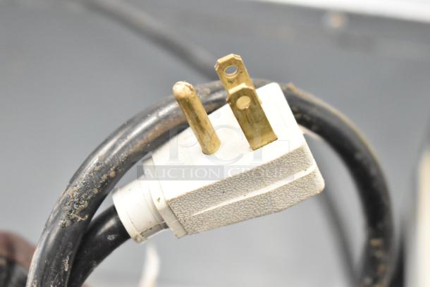 Close-up of a power plug for a 2021 True TUC-24F-HC commercial freezer, showing some wear on the cord.
