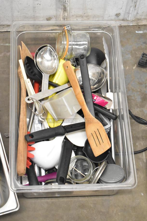 Lot of assorted items in a bin, featuring kitchen utensils, a CAL-6B Calculagraph, glass jars, and tape. Mixed condition.