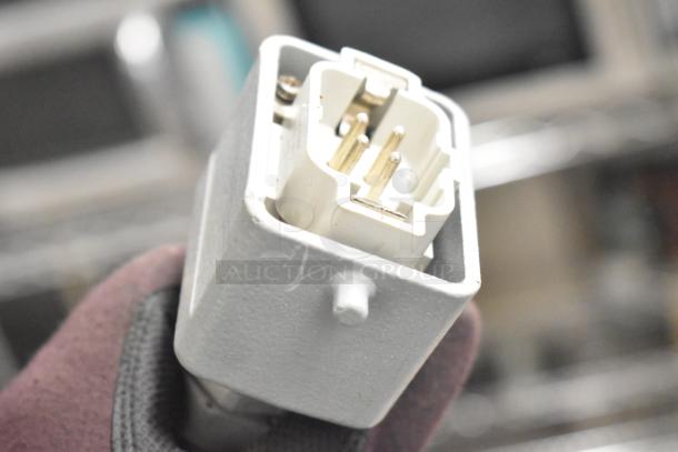 Luohe Orange 220V 3-phase commercial filling machine plug close-up, showing prongs and casing detail.