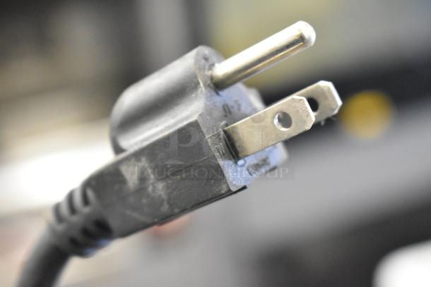 Close-up view of a power plug for the 2023 C12 Countertop Semi Automatic Round Bottle Labeling Machine, 220V, 1 Phase.