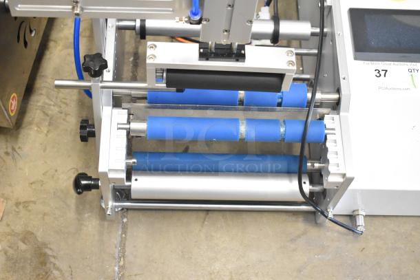 2023 C12 Semi Automatic Round Bottle Labeling Machine, 220V, 1 Phase, features blue rollers, excellent condition.