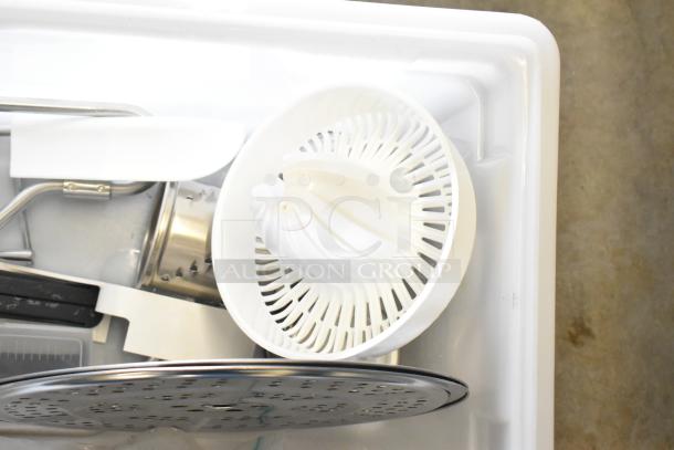 Lot with assorted items: white citrus juicer part, silver pan, kitchen timer, in good condition, within a white bin.