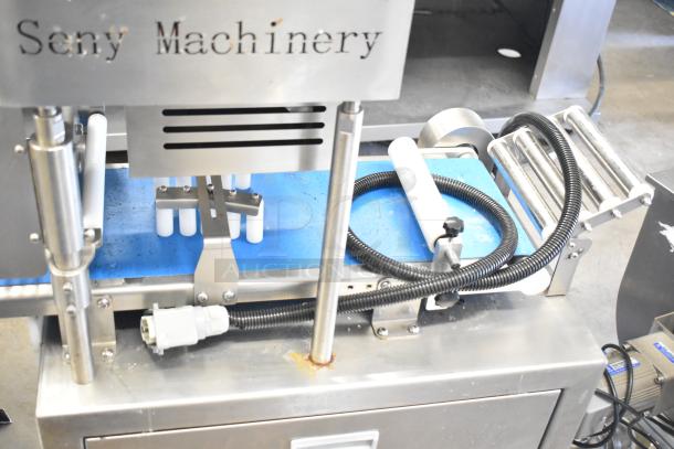 Seny Machinery commercial slicer and conveyor on casters, 220 volts, white rollers, visible brand engraving, used condition.