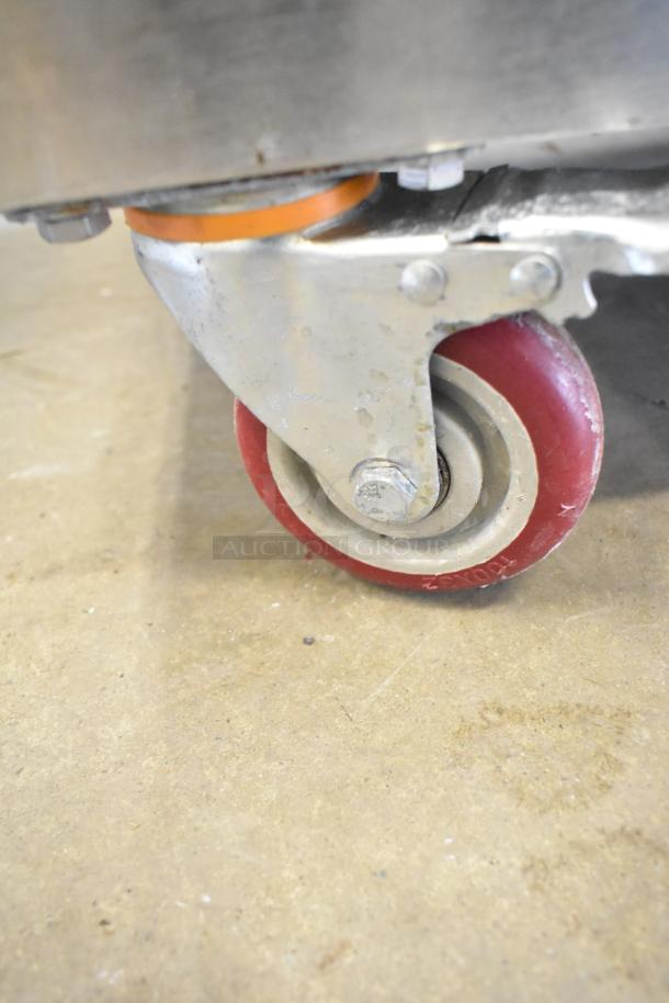 Stainless steel caster of Seny Machinery commercial slicer and conveyor machine. Red wheel for mobility. 220V.