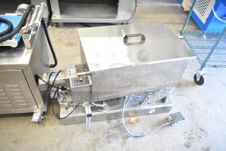 Commercial countertop meat mixer with foot pedal, stainless steel exterior, visible control panel, used condition.