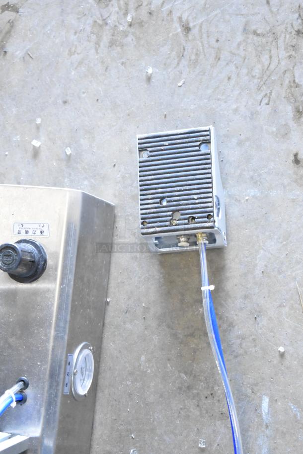 Commercial countertop meat mixer with attached foot pedal, stainless steel finish, visible tubing, in used condition.