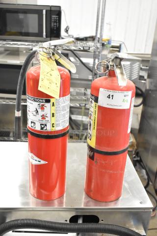 Two Amerex dry chemical fire extinguishers, red with instruction labels; buyer pick-up required, no shipping.