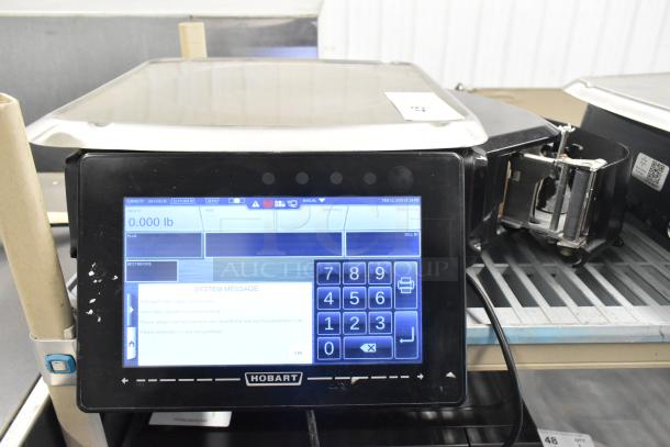 2017 Hobart HTi-7LH26 metal countertop food scale. Touchscreen display, good condition, 120/208-240V, 1 phase. Tested and working.