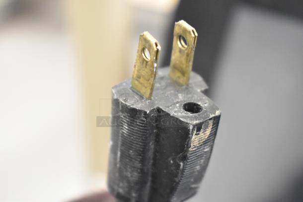 Close-up image of a power plug from a 2017 Hobart HTi-7LH26 commercial food portioning scale, showing wear.