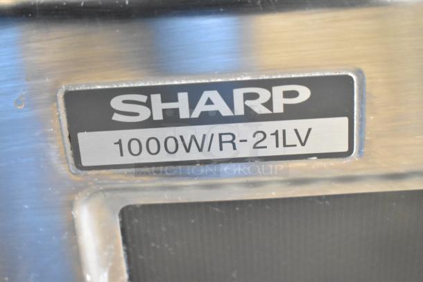 Sharp countertop microwave, model R-21LV, 1000W. Door is stuck closed. Label shows power details. 120V, 1 phase.