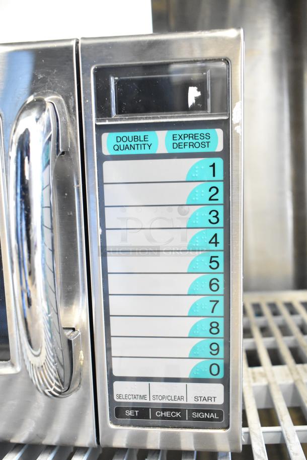 Sharp countertop microwave with a stuck door. Features keypad with functions. 120 volts, 1 phase. Stainless steel finish.