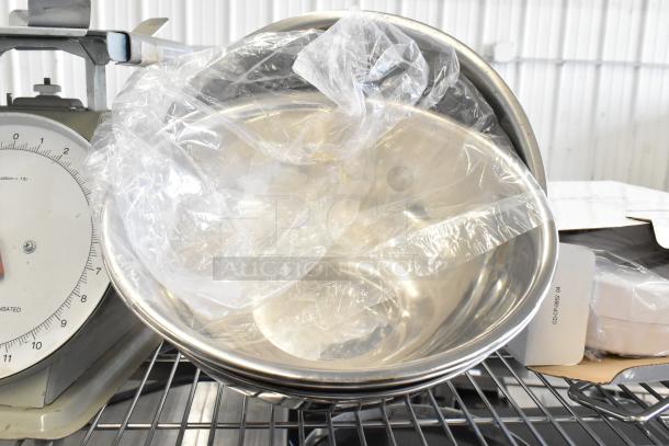 Three various scales, including a Detecto SCS30A hanging produce scale, displayed on a metal rack; some wrapped in plastic.