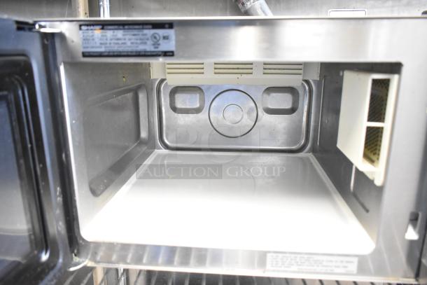 2023 Sharp R-21LVF commercial microwave oven, interior view. 120 Volts, excellent condition. Model and safety labels visible.