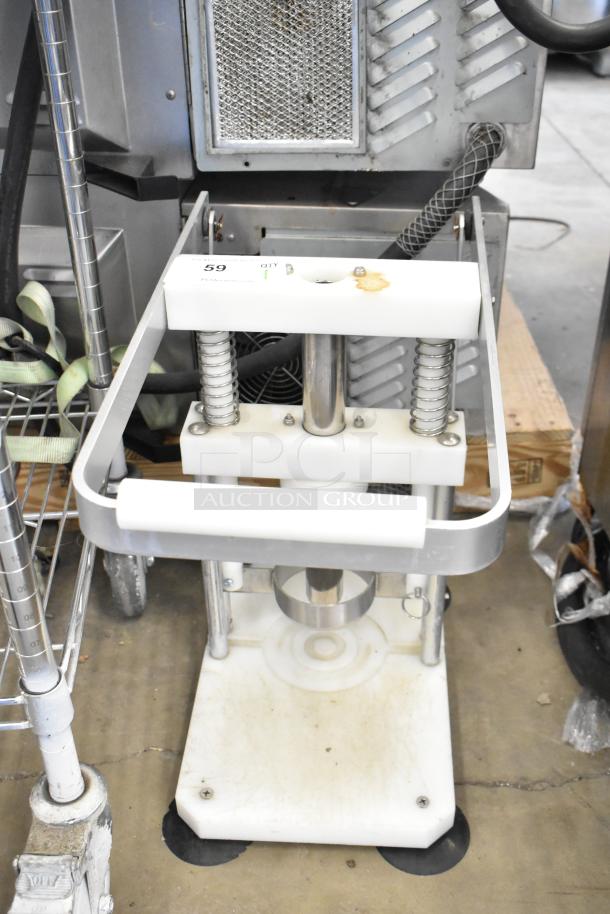 Countertop pineapple corer with metal frame and springs, signs of use visible. Effective for quick pineapple preparation.