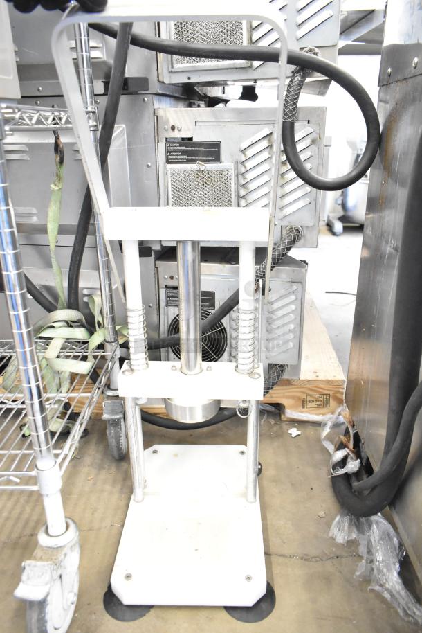 Countertop Pineapple Corer in used condition, featuring a sturdy metal frame and base. Ideal for efficient fruit coring.