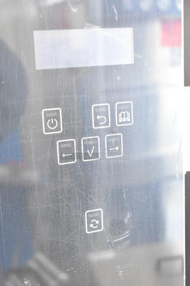 Fri-jado electric rotisserie oven control panel. Features power button, navigation arrows, and settings icon. 208V, 3 phase.