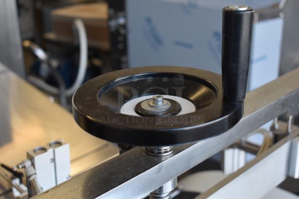 Commercial paper tube labeling machine, featuring a control handle. Operates at 208/250 volts, 1 phase. Appears in good condition.